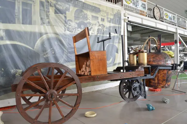 Carreta/locomóvil a vapor: chasis de madera con grandes ruedas de rayos de madera, caldera de cobre y carga de leña (réplica de vehículo a vapor)